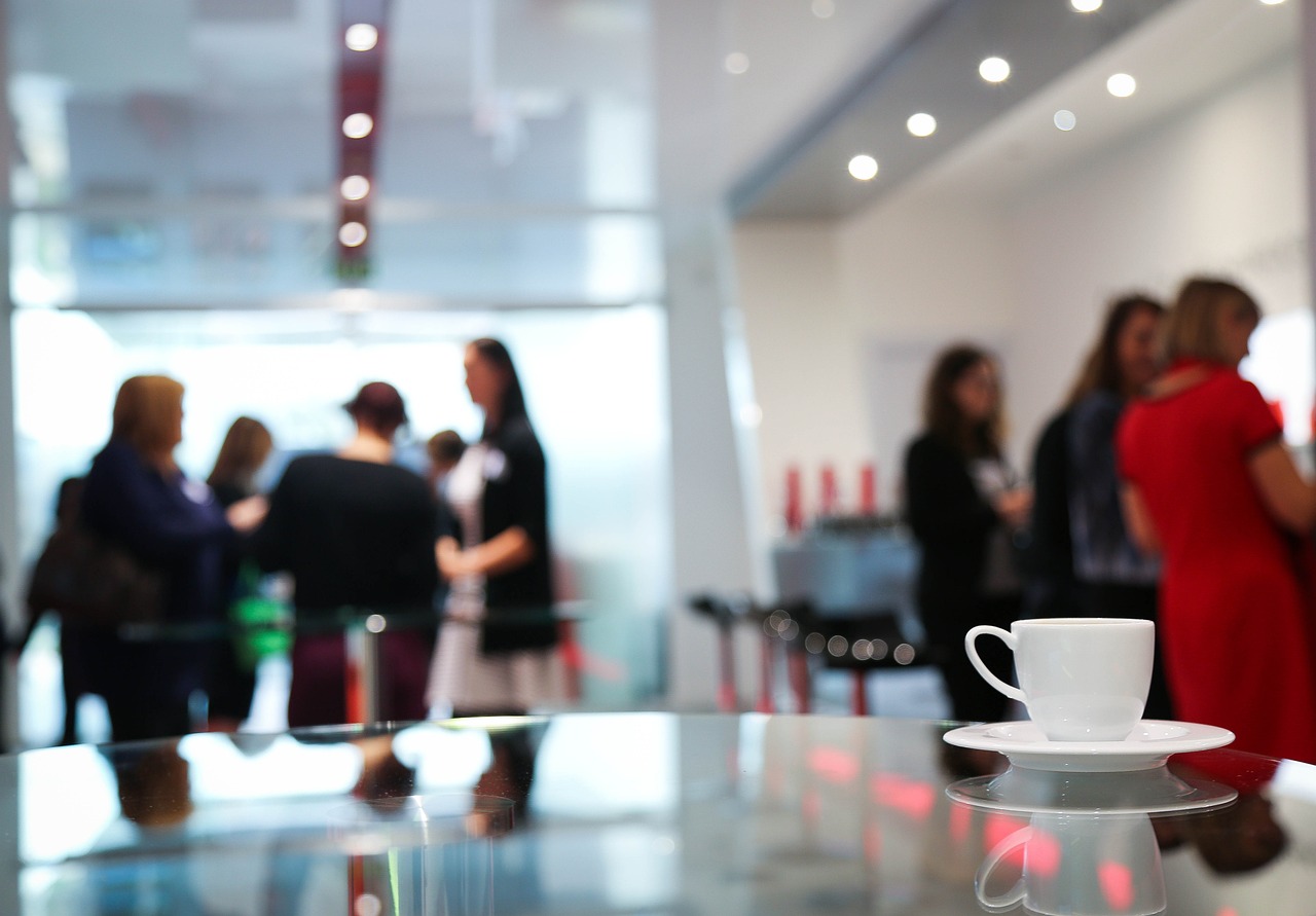 Frauen stehen zusammen und besprechen bei Kaffee